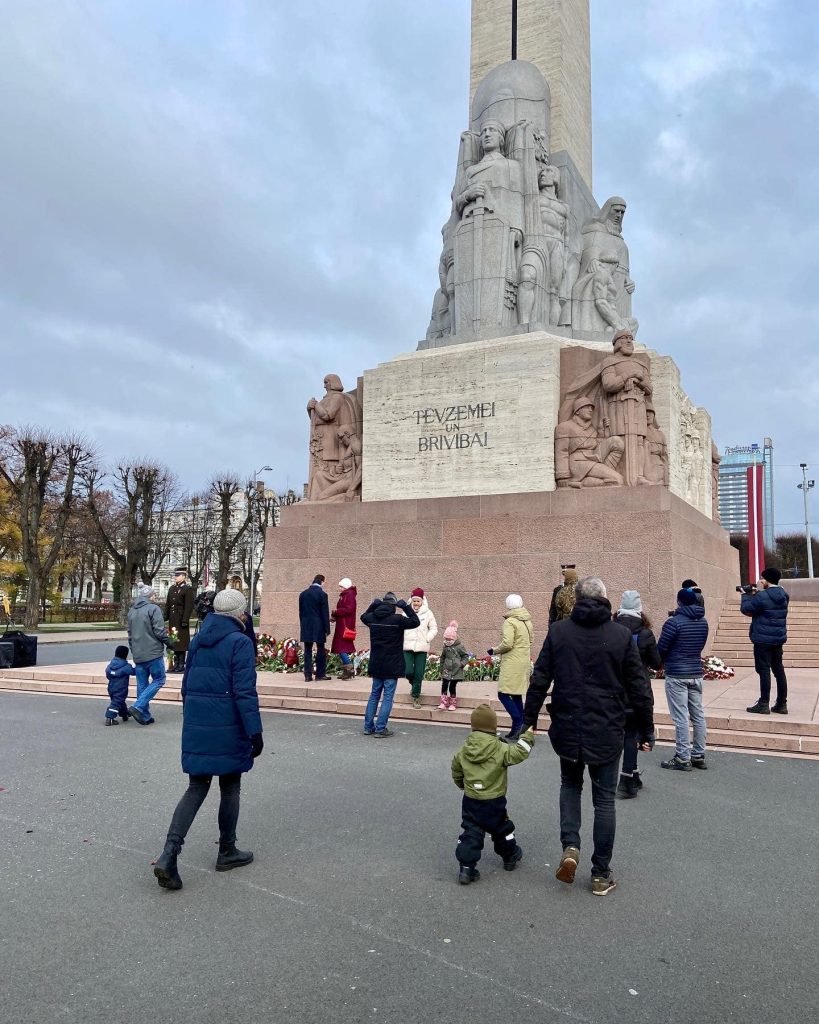 people lay flowers at the freedom monument in Riga, Latvia